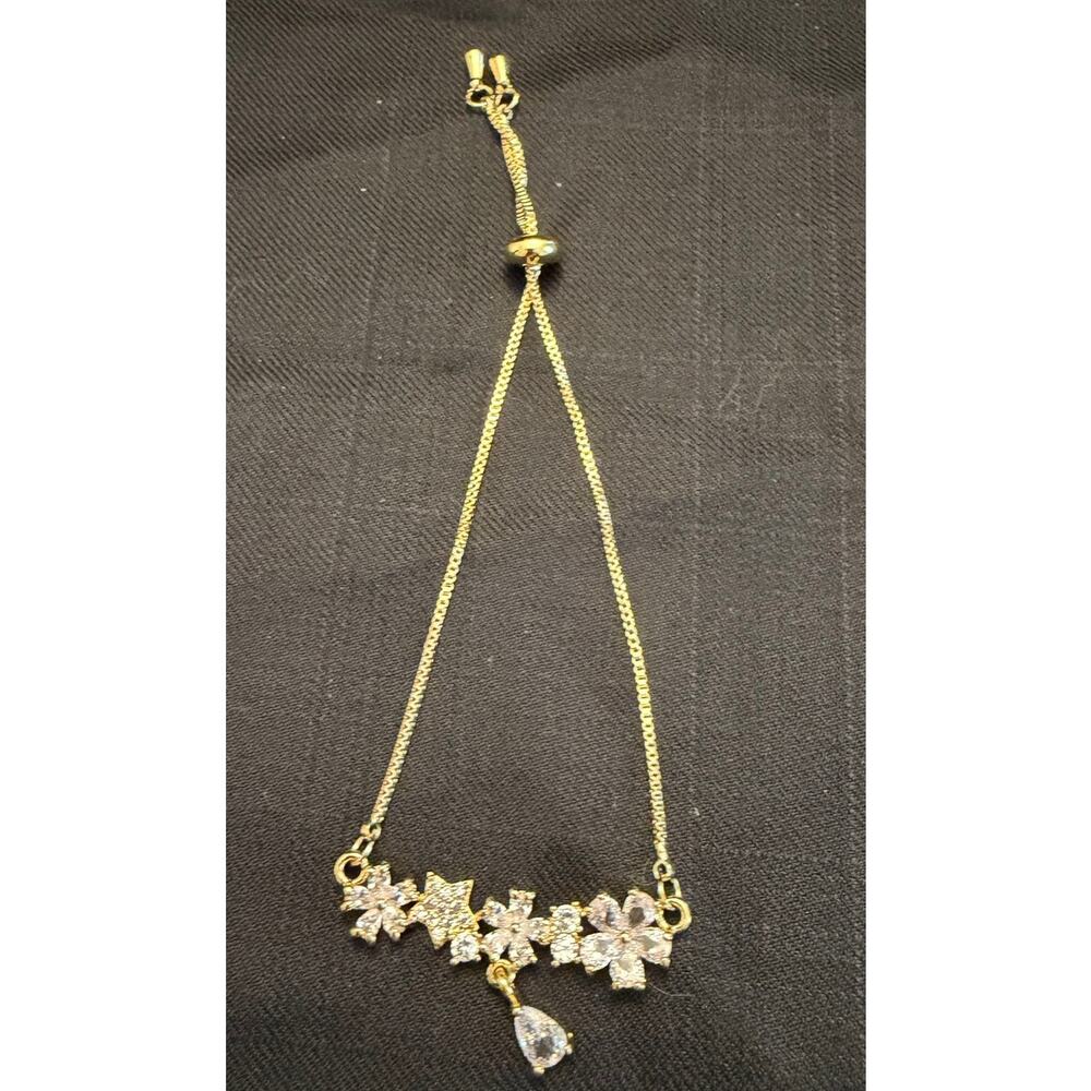 NWOT Glam 14k gold stainless steel adj floral bolo bracelet CZ flower and stars